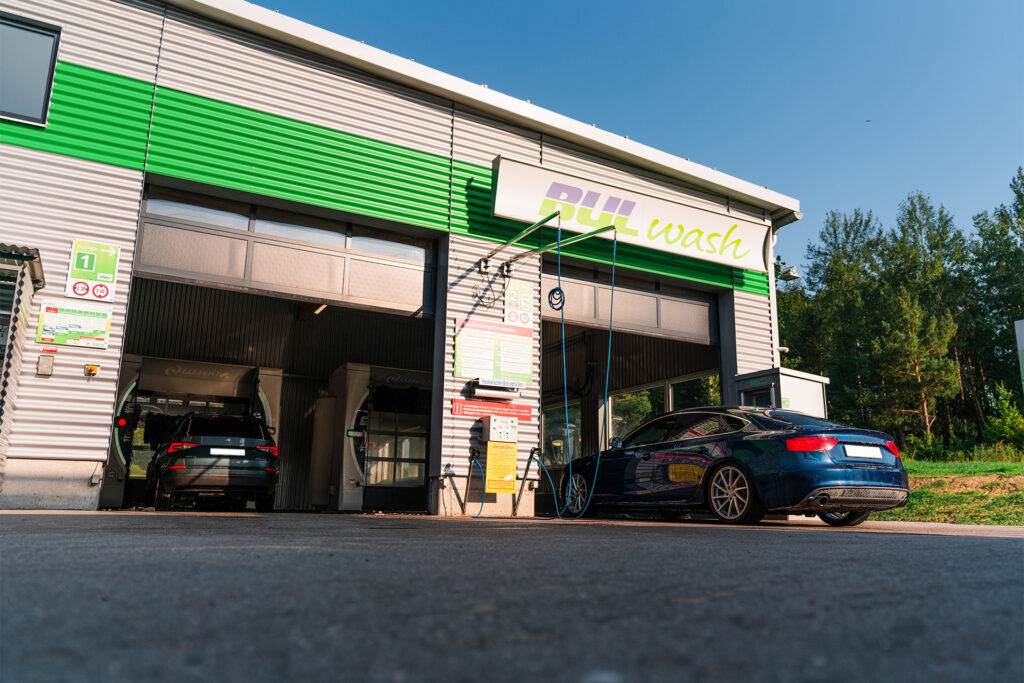 Einfahrt der Autowaschstraße, zwei PKW fahren gerade ein